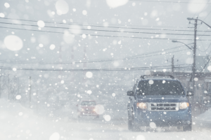 Cars driving on a snowy road, highlighting winter safety and the importance of proactive measures to manage workplace risks and WCB claims.